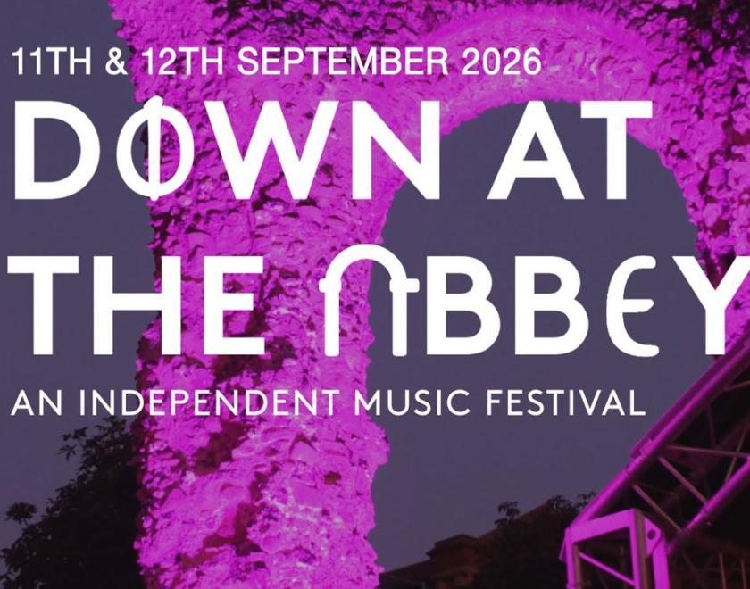Down At The Abbey event poster with logo over a photo of the Abbey Ruins