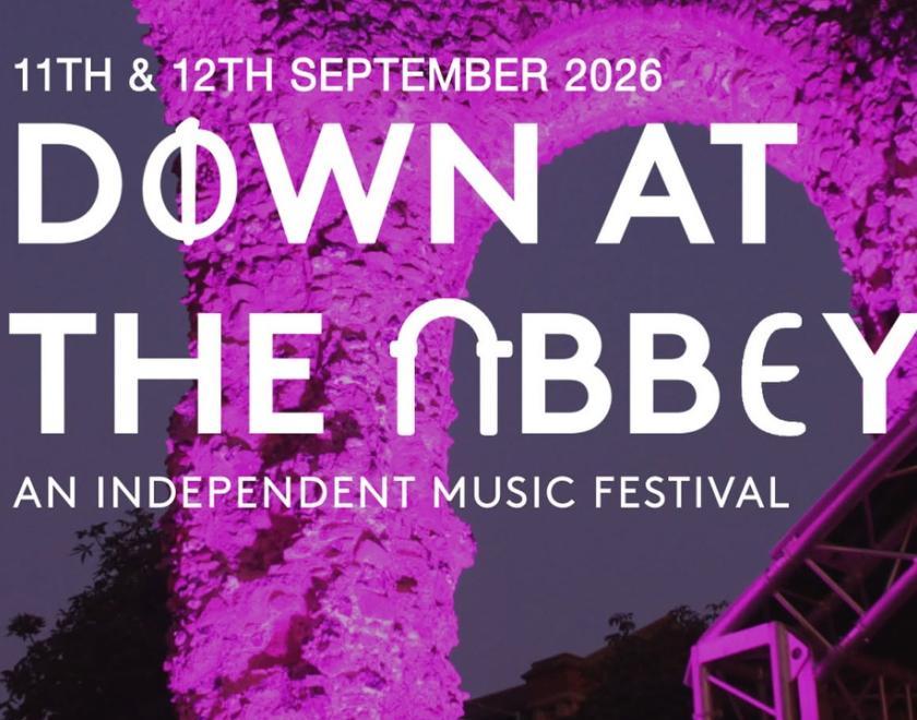 Down At The Abbey event poster with logo over a photo of the Abbey Ruins