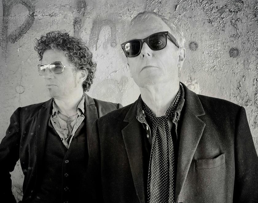 Black and white photo of two middle-aged men in sunglasses and leather jackets