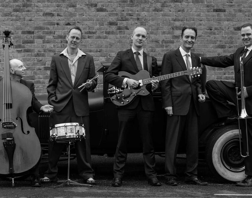 five-piece swing band holding their instruments