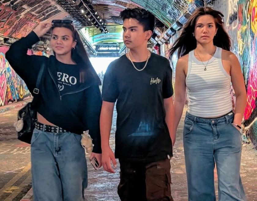 Three teenage punks standing in a grafitti'd tunnel
