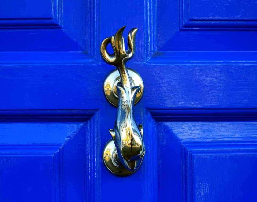 elaborate door knocker on blue door