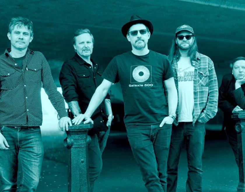 Green monochrome photo of five members of Dreaming Spires band, standing in an urban environment