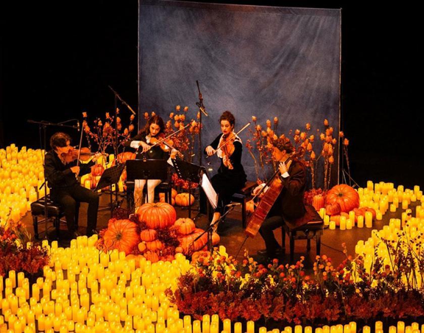 String quartet surrounded by candles and pumpkins