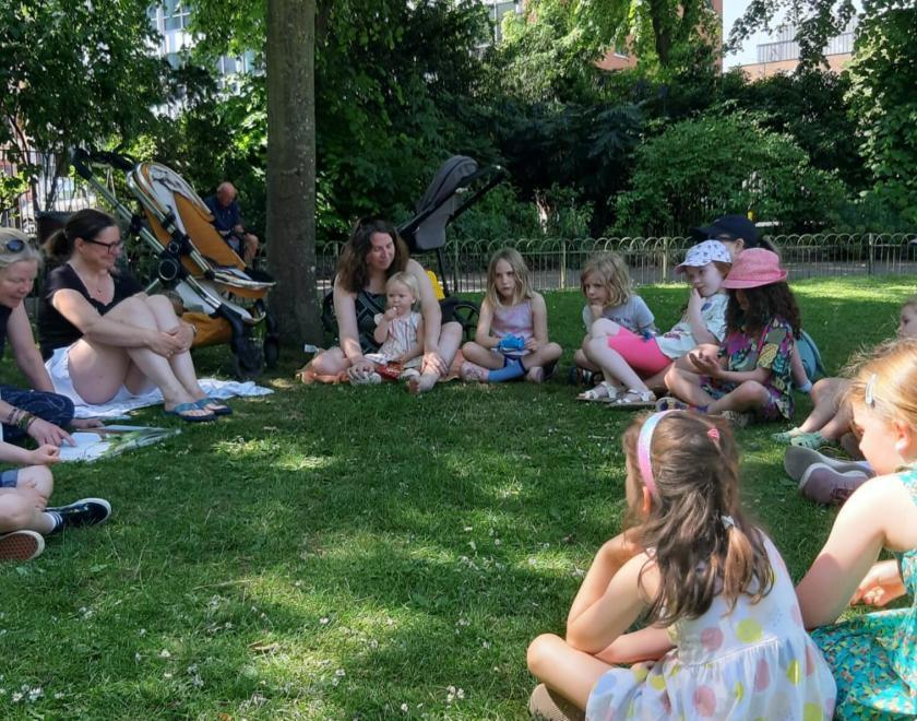 Children sitting in a circle in Forbury Gardens