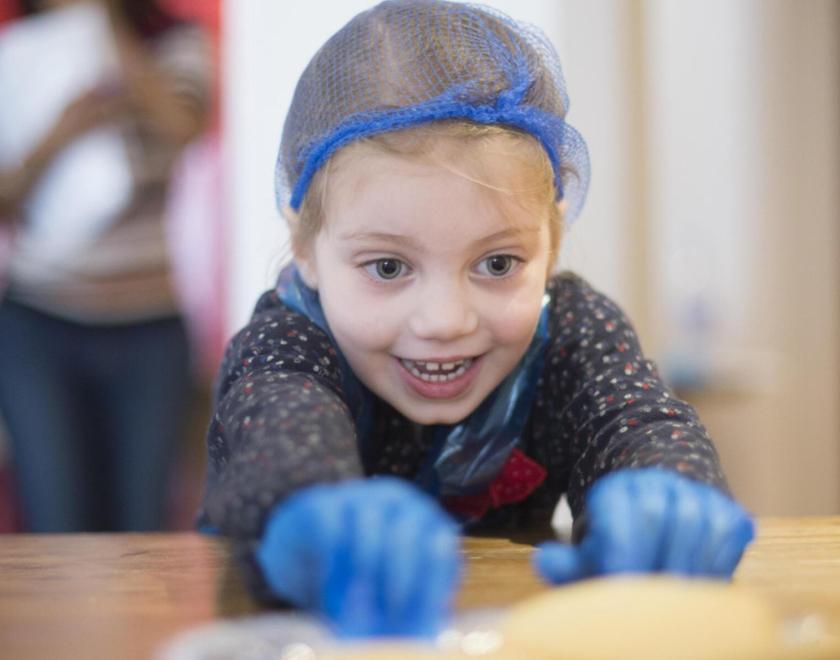 Young girl in a hairnet and plastic gloves, smiling