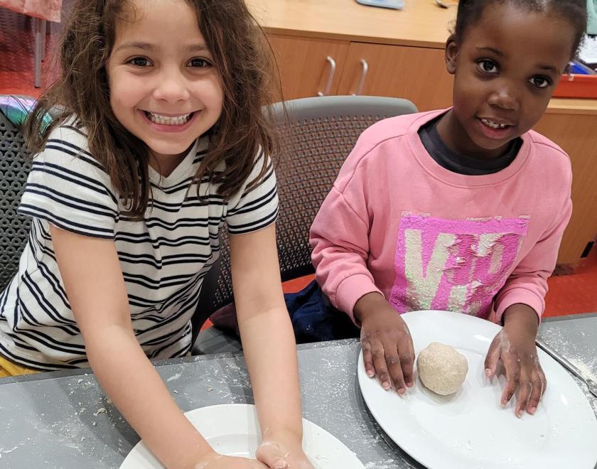 Young girls rolling dough