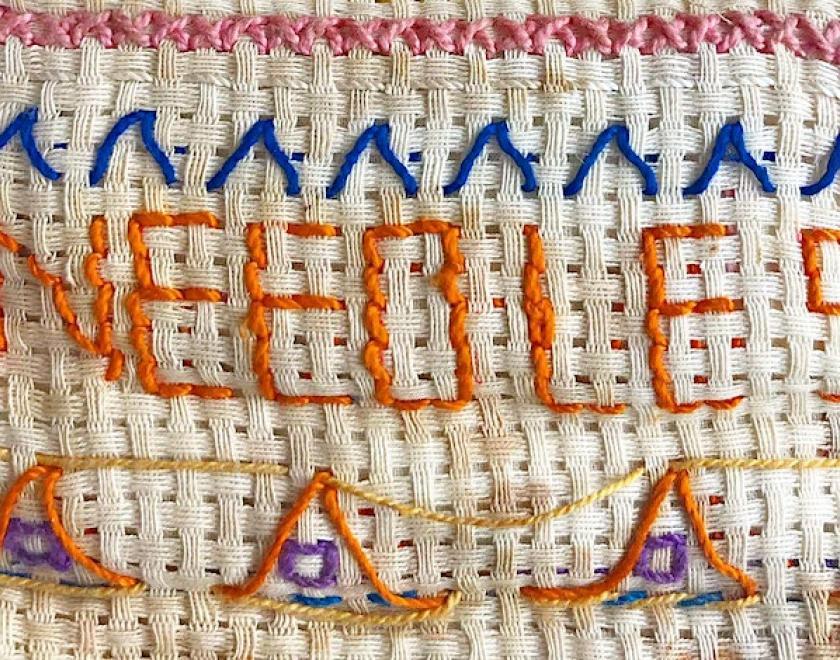a stitched panel spelling out the words needles