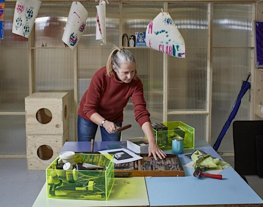 artist using printmaking tools in the studio