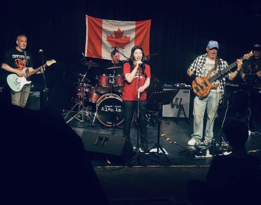 Jagged Little Alanis band on stage in front of a Canadian flag
