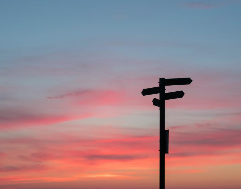 A signpost against a sunset