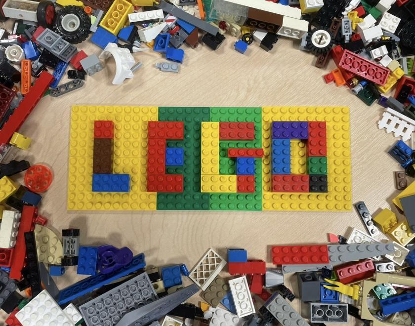 Lego figures holding a LEGO globe