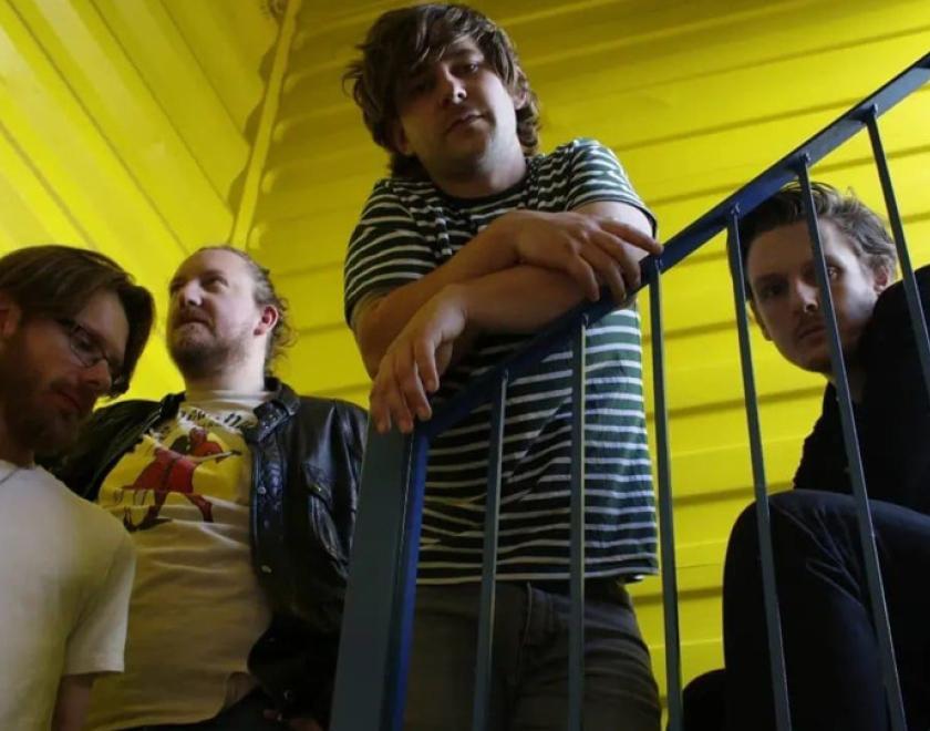 the band Mellor gathered round a stairwell in a yellow shipping container