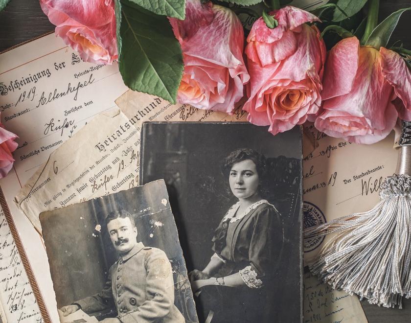 Old photos, flowers and documents on a desk