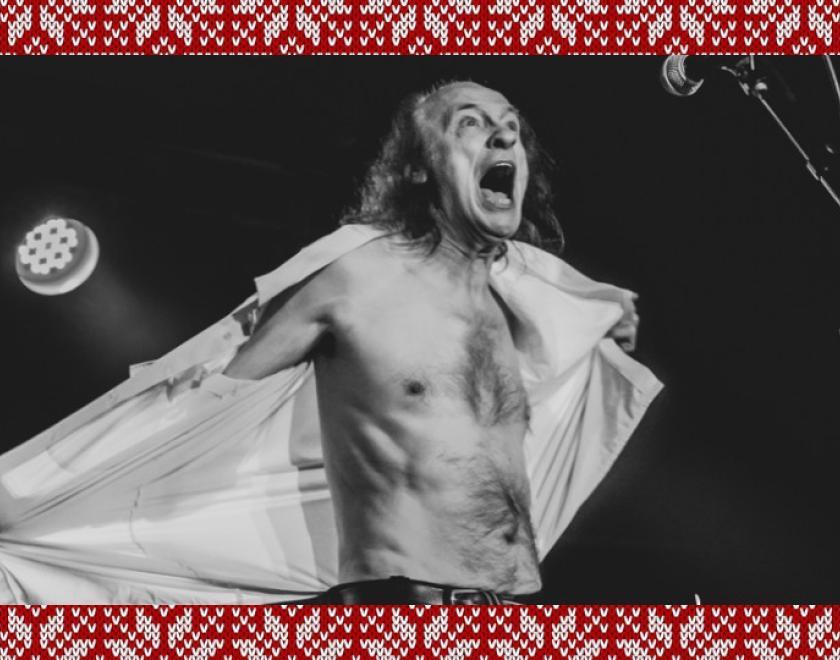 Black and white photo of singer John Otway ripping open his shirt