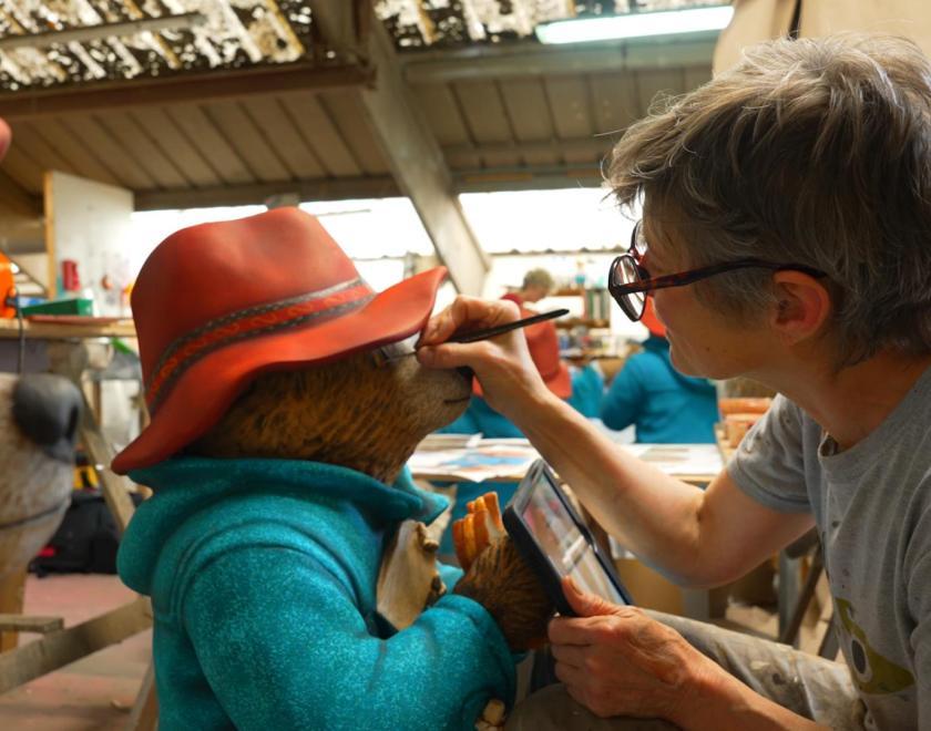 artist painting a model of Paddington Bear