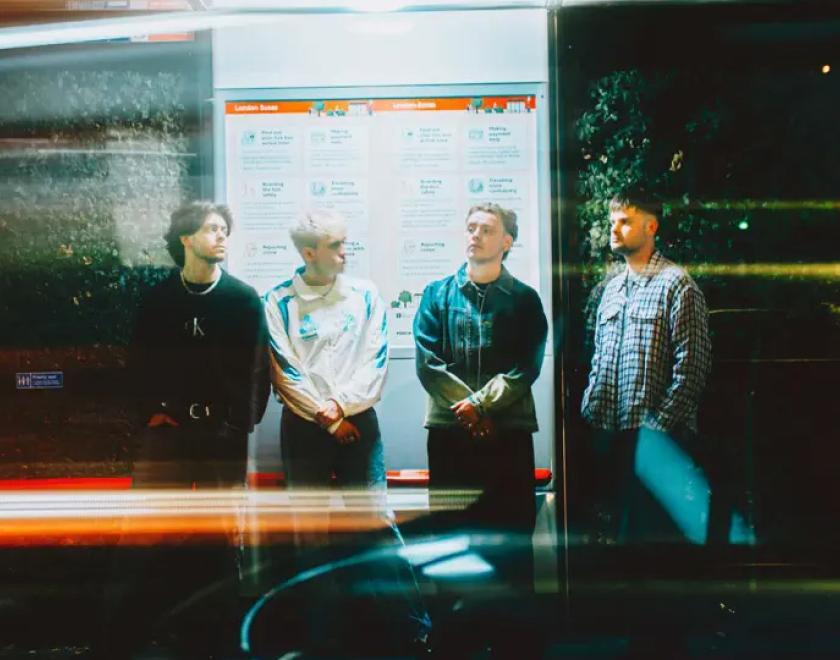 Only the Poets band members standing in a bus stop