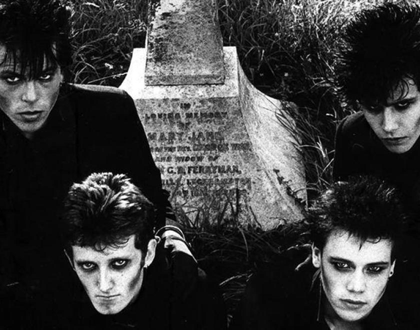 Screaming Dead members in gothic hair and make up sitting around a gravestone