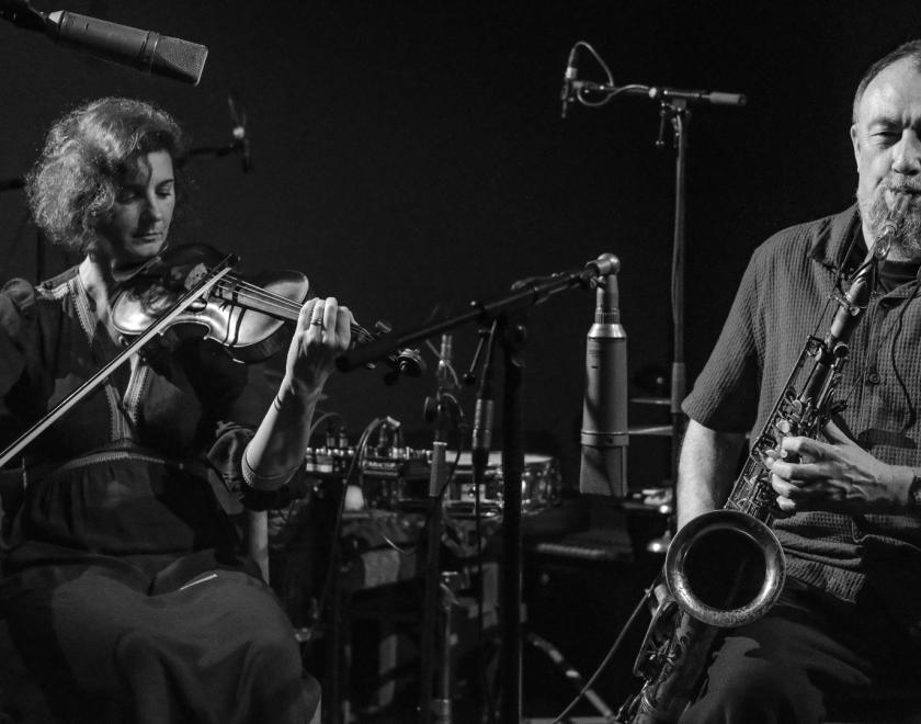 Black and white photo of John Butcher on the saxophone and Angharad Davies on the violin