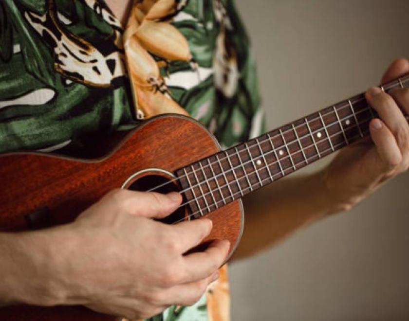 student holding ukulele